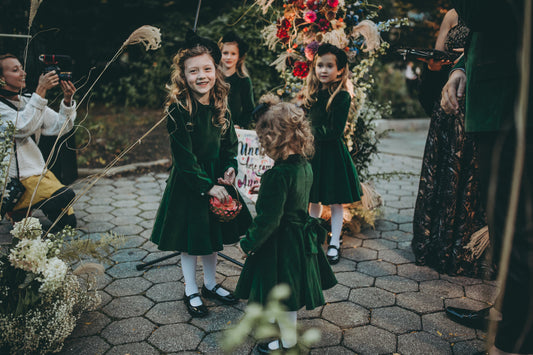 Little girls dancing in green velvet dresses.