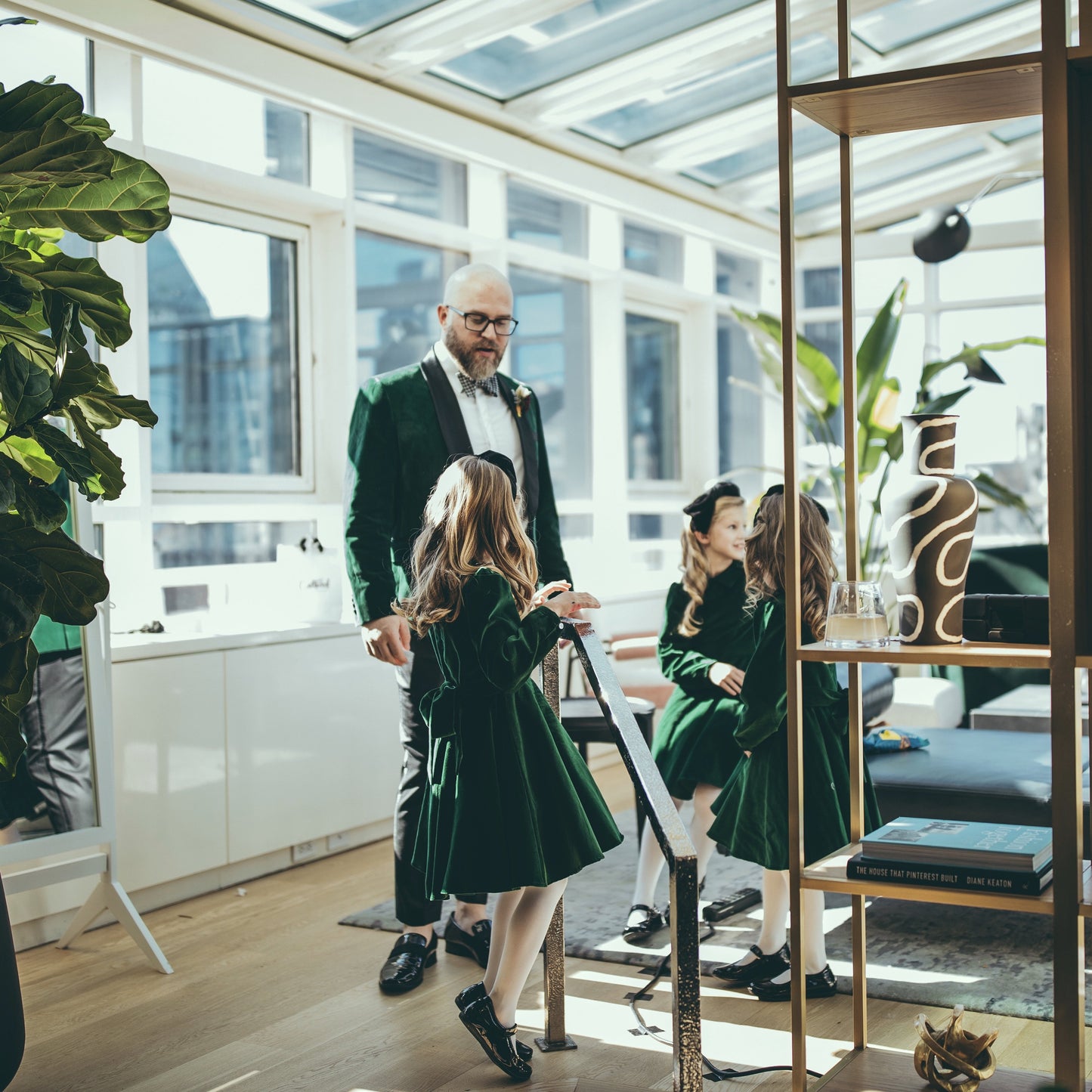 Little girl in a green velvet dress talking to a groom.